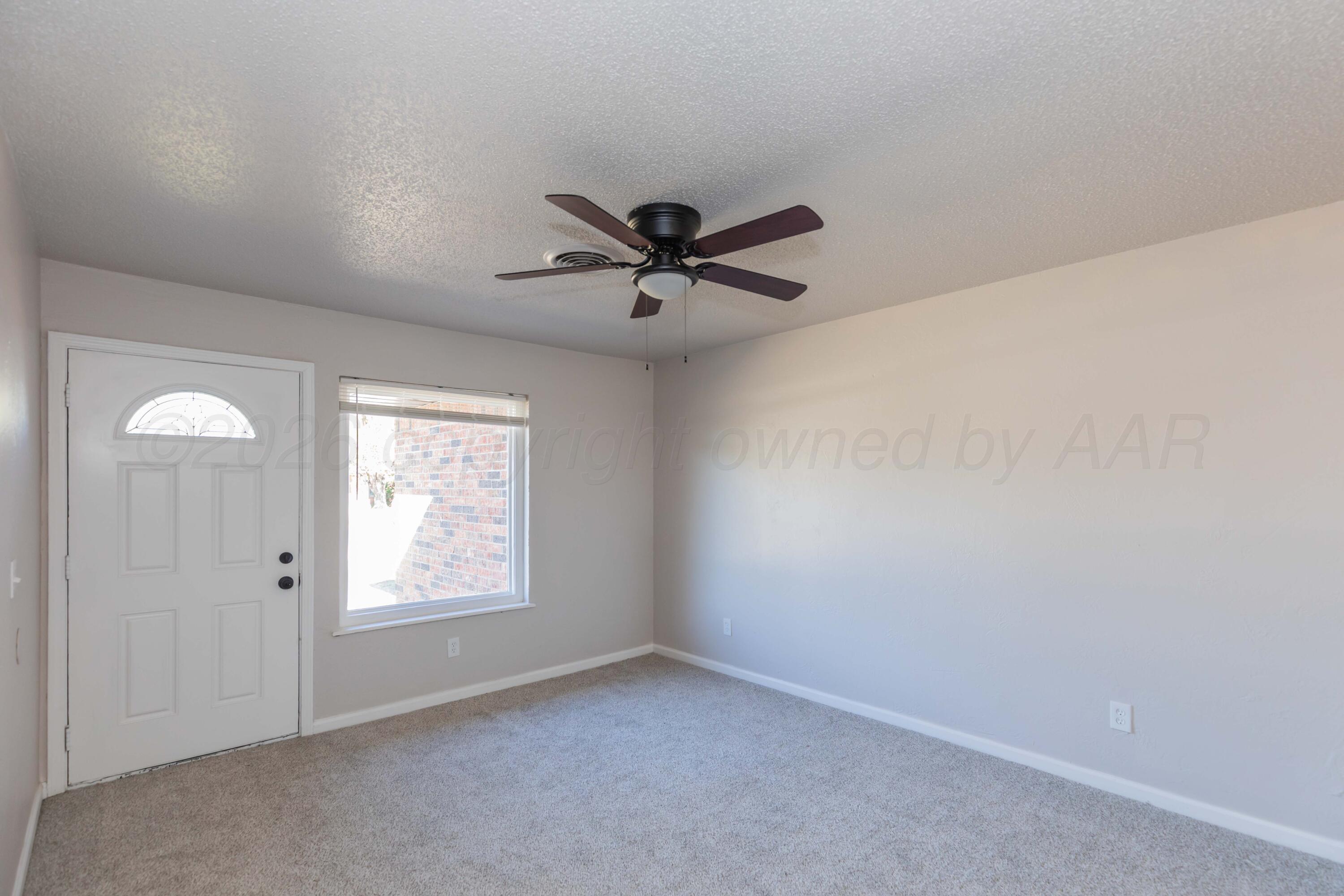 2915 Hodges Street Amarillo, TX 79103 - Photo 3 of 34 an empty room with windows and fan