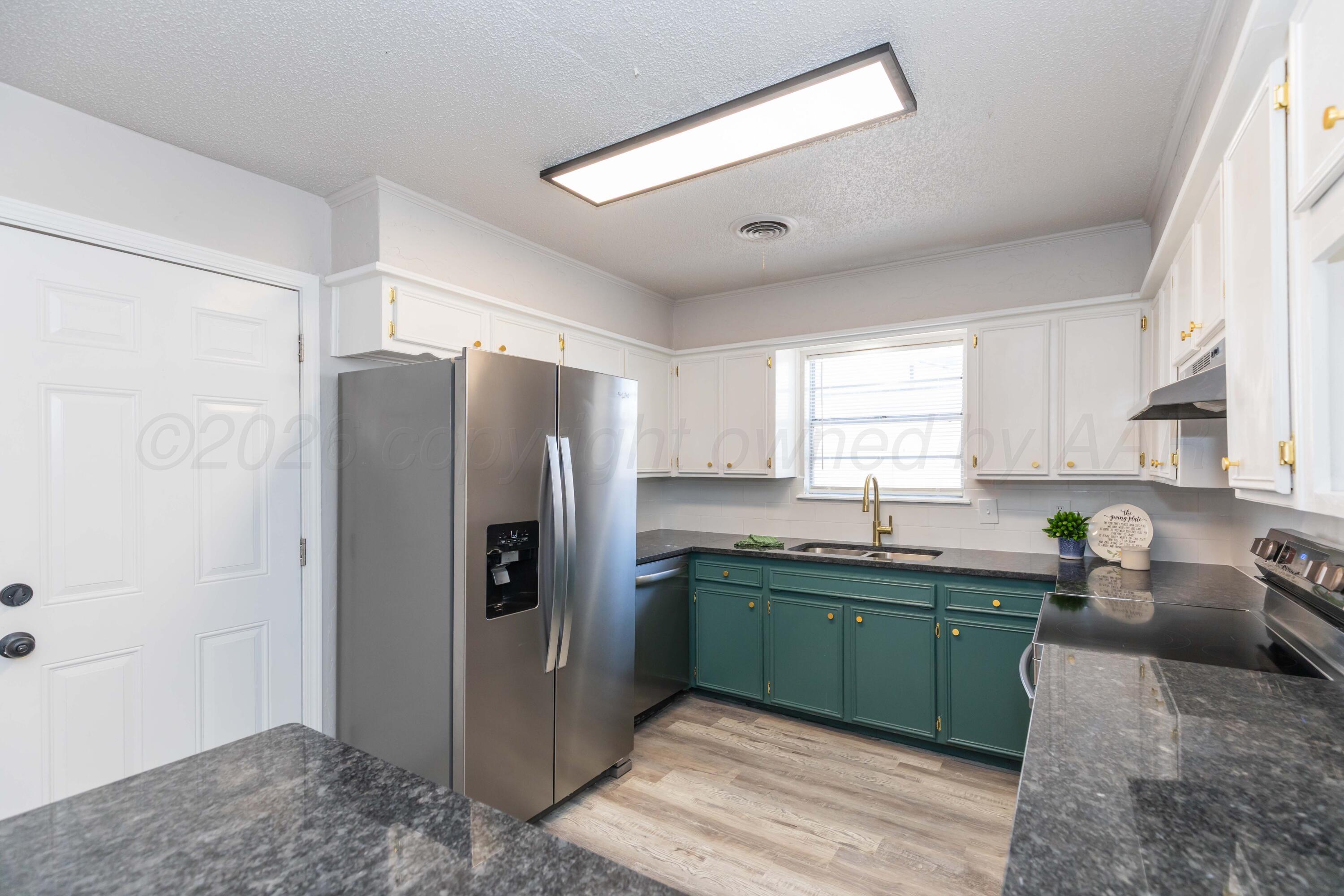 2915 Hodges Street Amarillo, TX 79103 - Photo 5 of 34 a kitchen with a refrigerator a sink and cabinets