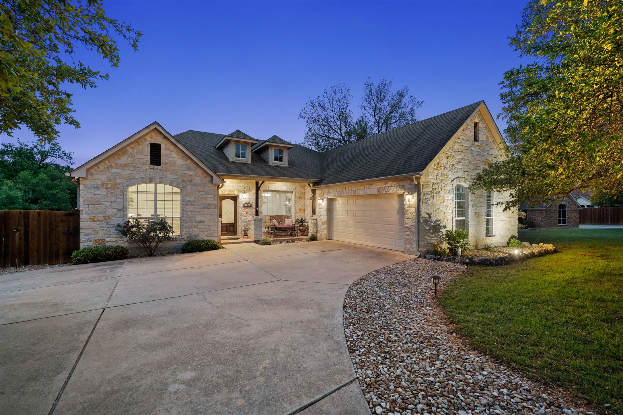 15208 Nightingale Lane Austin, TX 78734 - Photo 1 of 40 French country style house featuring stone siding, driveway, an attached garage, a porch, and roof with shingles