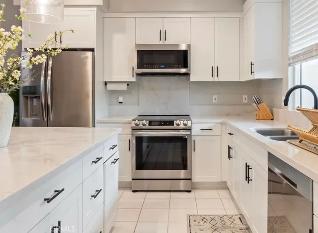 a large kitchen with kitchen island a large counter space and stainless steel appliances