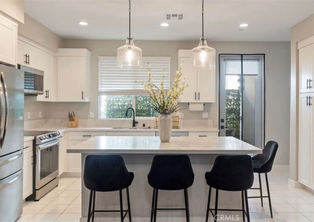 2111 Copper Walk Gardena, CA 90249 - Photo 9 of 33 a kitchen with stainless steel appliances granite countertop a sink a stove a refrigerator and island with wooden floor