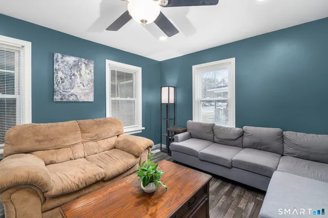 a living room with furniture and a wooden floor