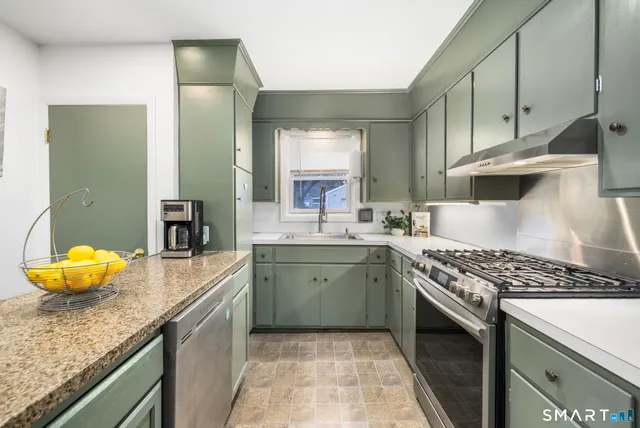 a kitchen with granite countertop a sink and a stove