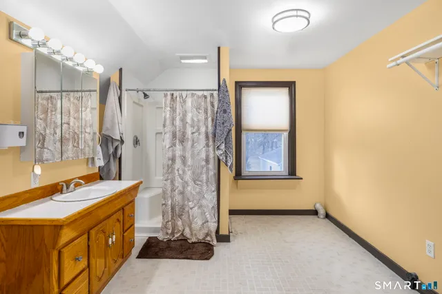 a bathroom with a tub sink and mirror
