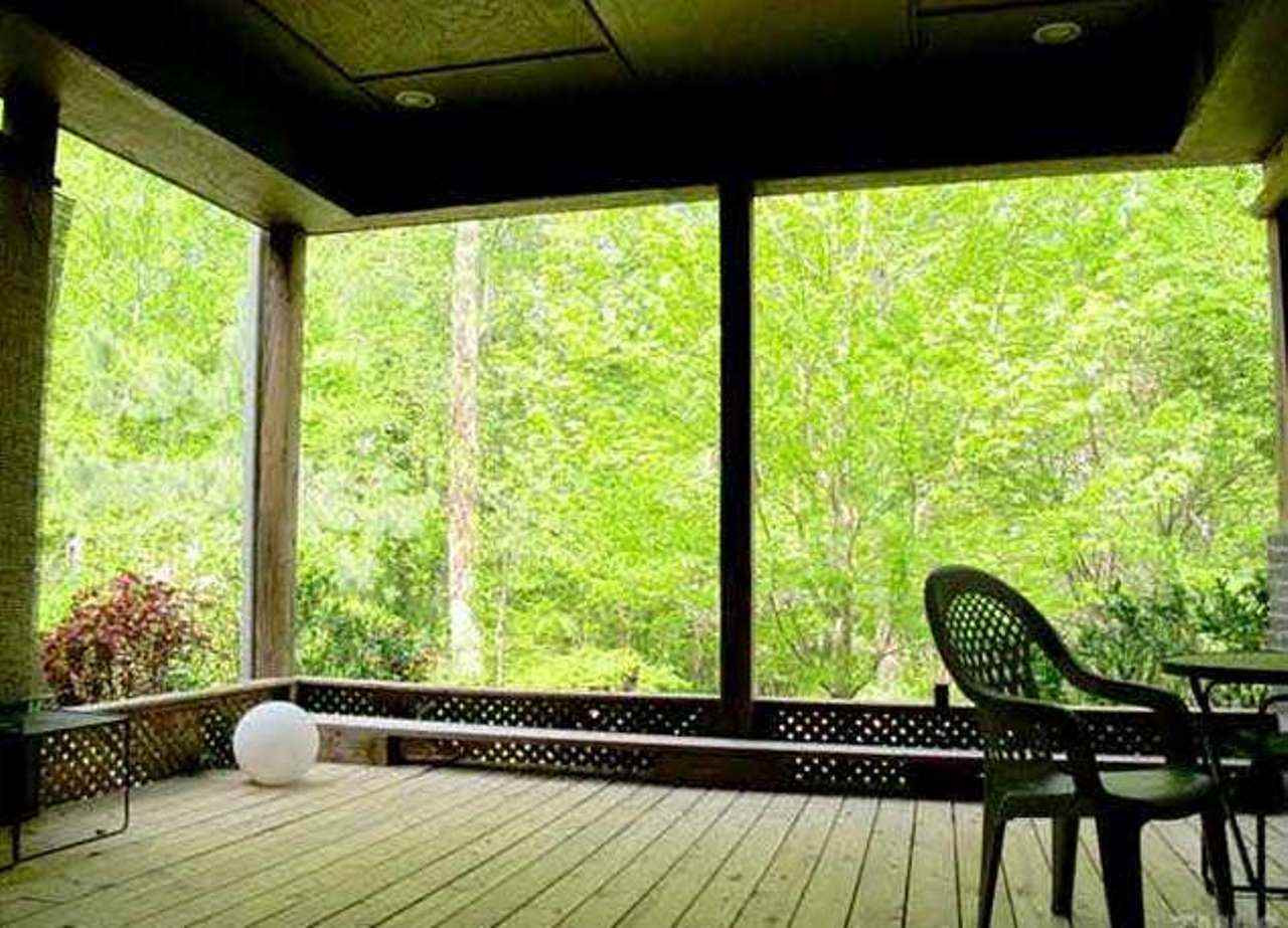 6909 Slade Hill Road Raleigh, NC 27615 - Photo 24 of 25 Lower level residence covered porch is expansive & accessible from master or by stone walkway. View from porch is very private looking out over backyard & koi pond. 18'x16' surrounding stone planter has gardenias, purple smoke trees and huge whisteria. Porch