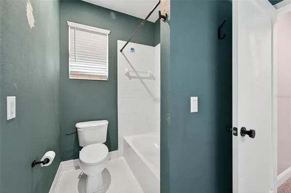 a view of an empty room with chandelier fan
