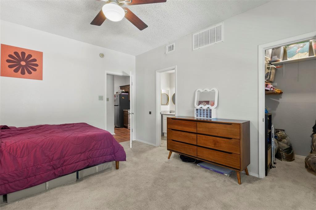 5616 Preston Oaks Road, Unit 1105 Dallas, TX 75254 - Photo 12 of 17 a bedroom with a bed and a chandelier