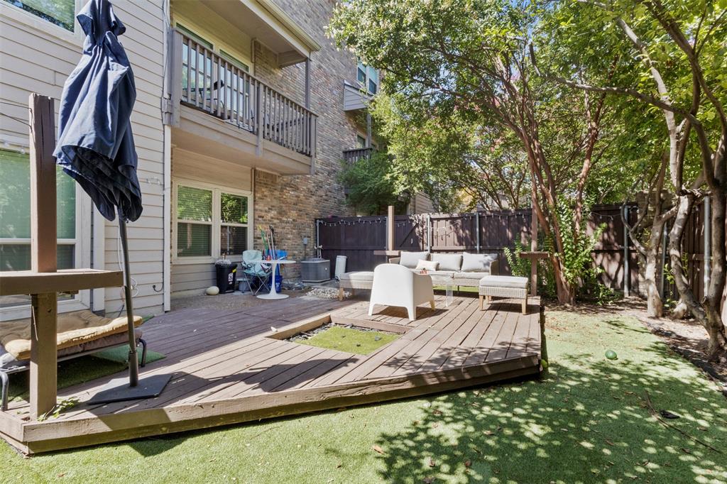 5616 Preston Oaks Road, Unit 1105 Dallas, TX 75254 - Photo 16 of 17 a view of a patio with table and chairs with wooden fence and plants