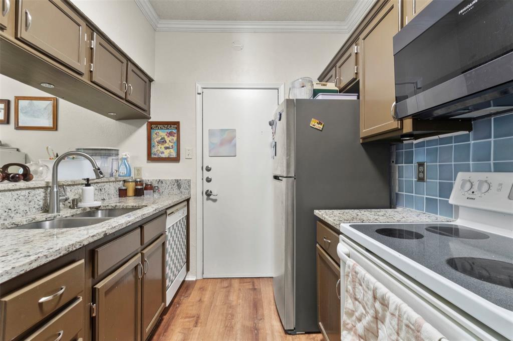 5616 Preston Oaks Road, Unit 1105 Dallas, TX 75254 - Photo 9 of 17 a kitchen with stainless steel appliances granite countertop a sink stove and refrigerator