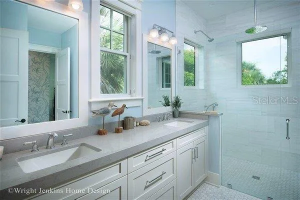 a bathroom with double vanity and a mirror