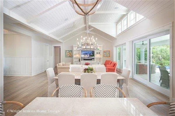 a view of a dining room with furniture a chandelier and wooden floor