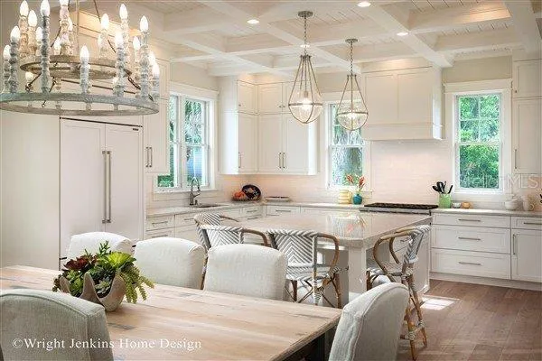 a living room with stainless steel appliances kitchen island granite countertop furniture and a chandelier