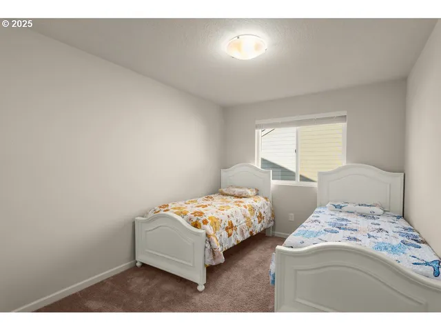 a bedroom with two bed and window