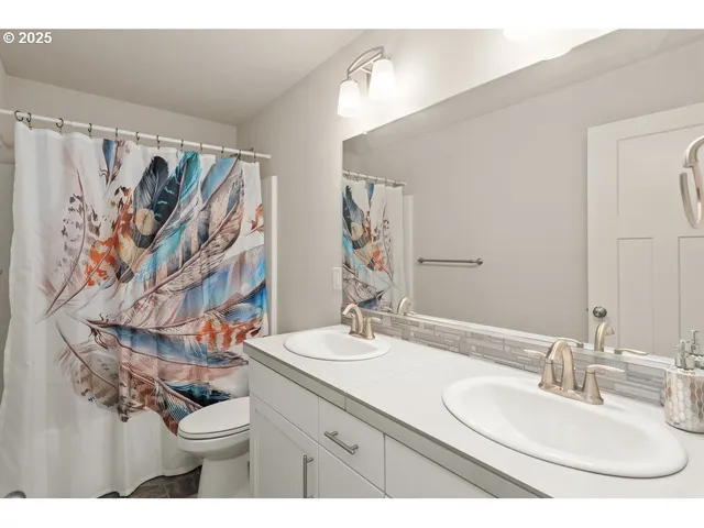 a bathroom with a granite countertop sink a toilet and a mirror