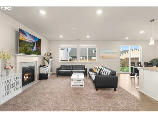 a living room with furniture a fireplace and a flat screen tv