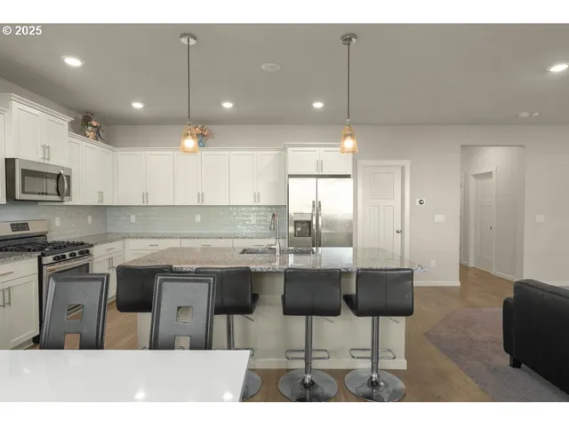 a kitchen with kitchen island granite countertop a sink and cabinets