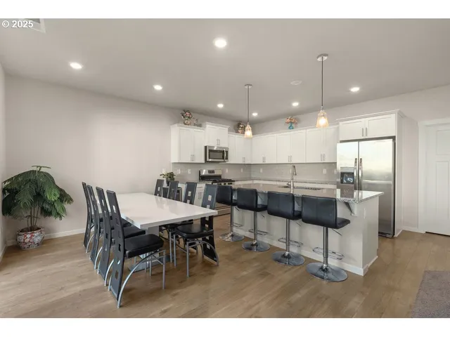 a kitchen with a dining table chairs and white cabinets