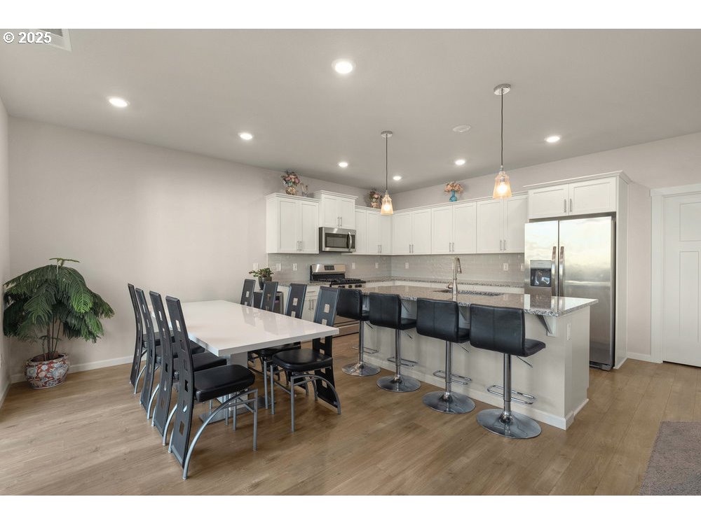 6421 Southeast 22nd Street Gresham, OR 97080 - Photo 7 of 39 a kitchen with a dining table chairs and white cabinets