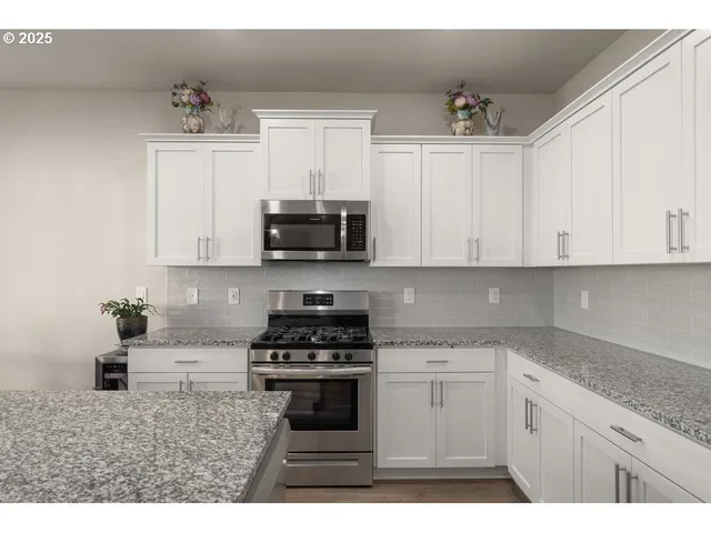 a kitchen with stainless steel appliances granite countertop a sink a stove a microwave and cabinets