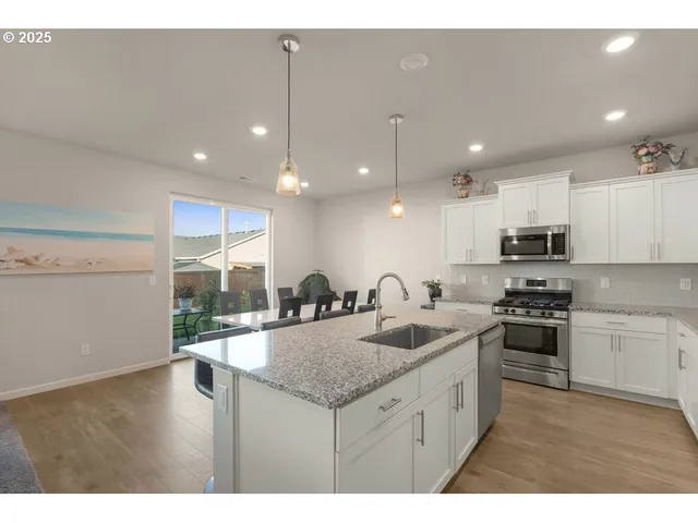 a kitchen with a sink a counter top space appliances and cabinets