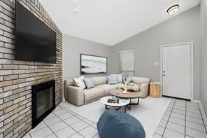 a living room with furniture a flat screen tv and a fireplace