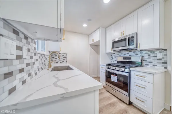 a kitchen with stainless steel appliances a stove microwave and cabinets