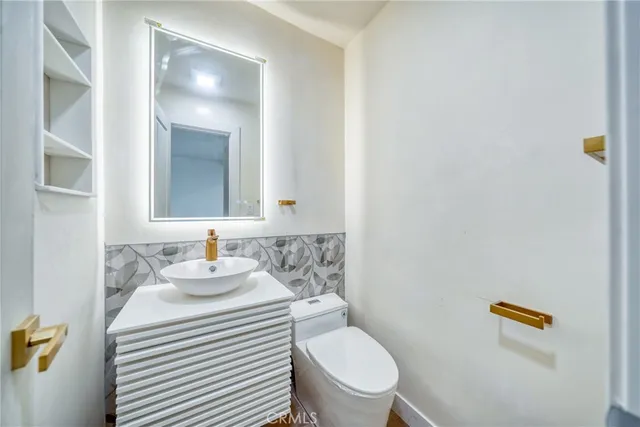 a bathroom with a toilet sink and mirror