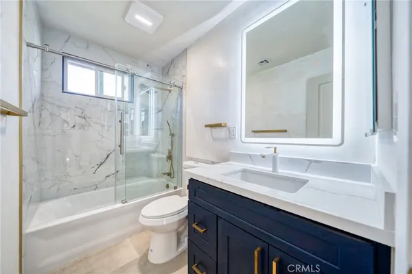 a bathroom with a sink a toilet and a large mirror