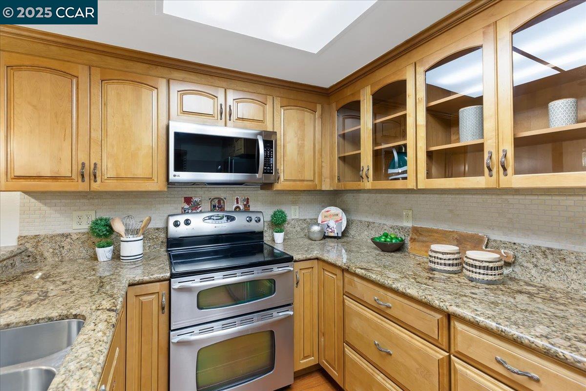 1857 Golden Rain Road, Unit 2 Walnut Creek, CA 94595 - Photo 20 of 39 a kitchen with granite countertop a sink stainless steel appliances and cabinets