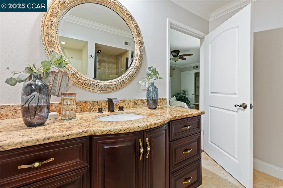 1857 Golden Rain Road, Unit 2 Walnut Creek, CA 94595 - Photo 25 of 39 a bathroom with a granite countertop sink a mirror and vanity