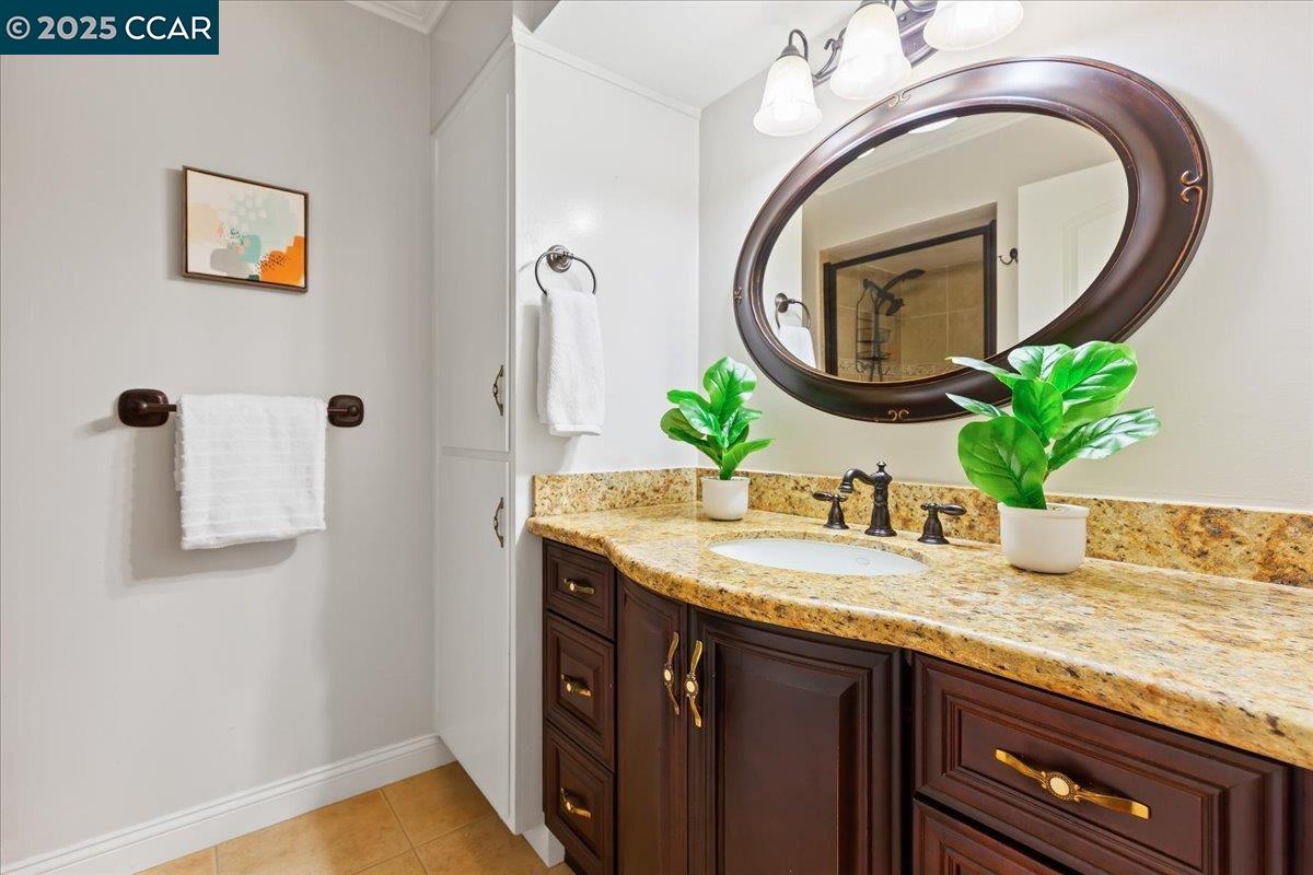 1857 Golden Rain Road, Unit 2 Walnut Creek, CA 94595 - Photo 29 of 39 a bathroom with a granite countertop sink and a mirror