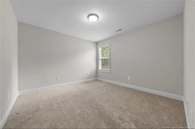 a spacious bathroom with a granite countertop sink a toilet and a mirror