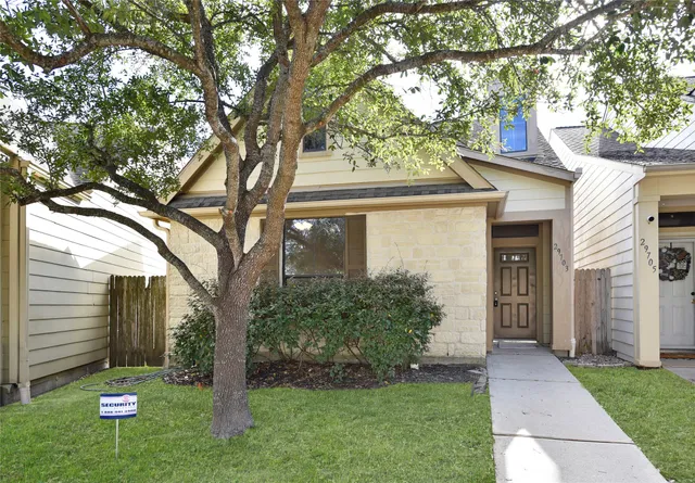 a front view of a house with a yard and tree