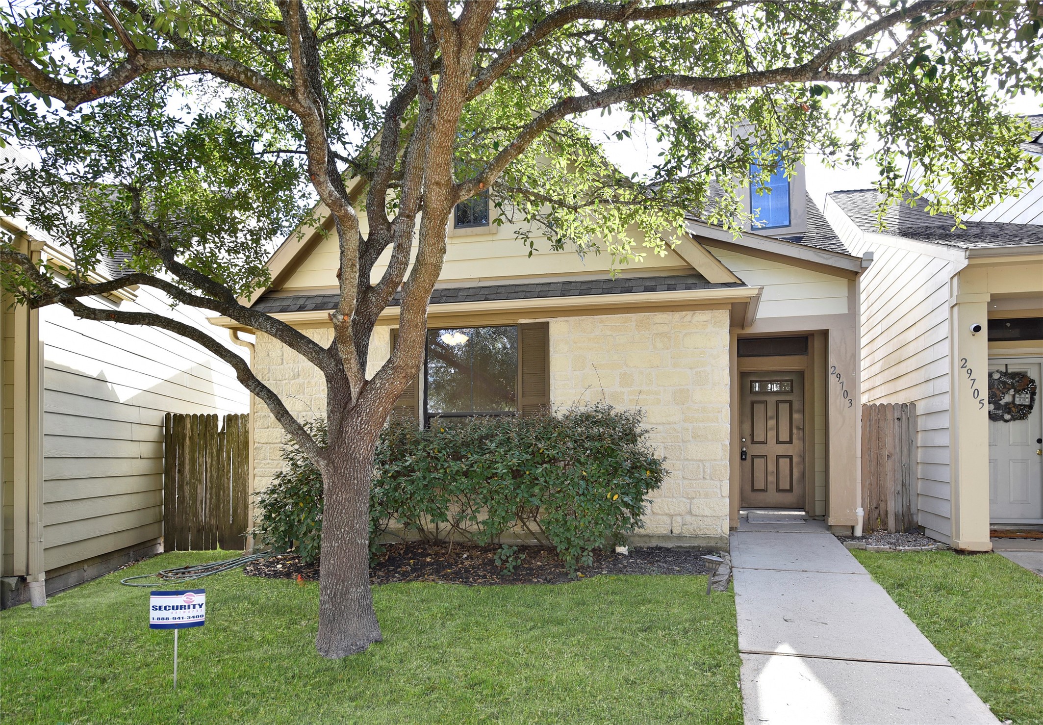 a front view of a house with a yard and tree