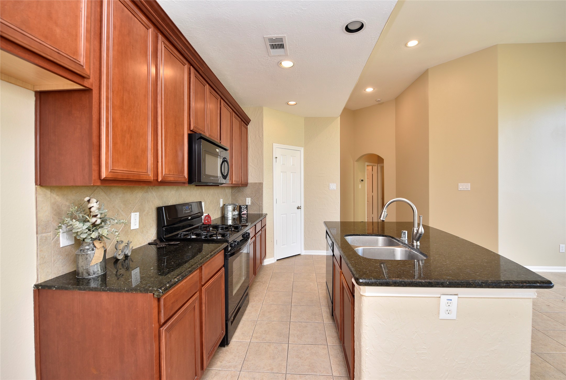 29703 Meridian Hill Drive Spring, TX 77386 - Photo 7 of 43 a kitchen with kitchen island granite countertop a sink stove top oven and cabinets