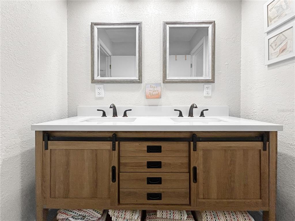 2505 Bay Boulevard, Unit 1 Indian Rocks Beach, FL 33785 - Photo 18 of 25 a bathroom with a sink and two mirror