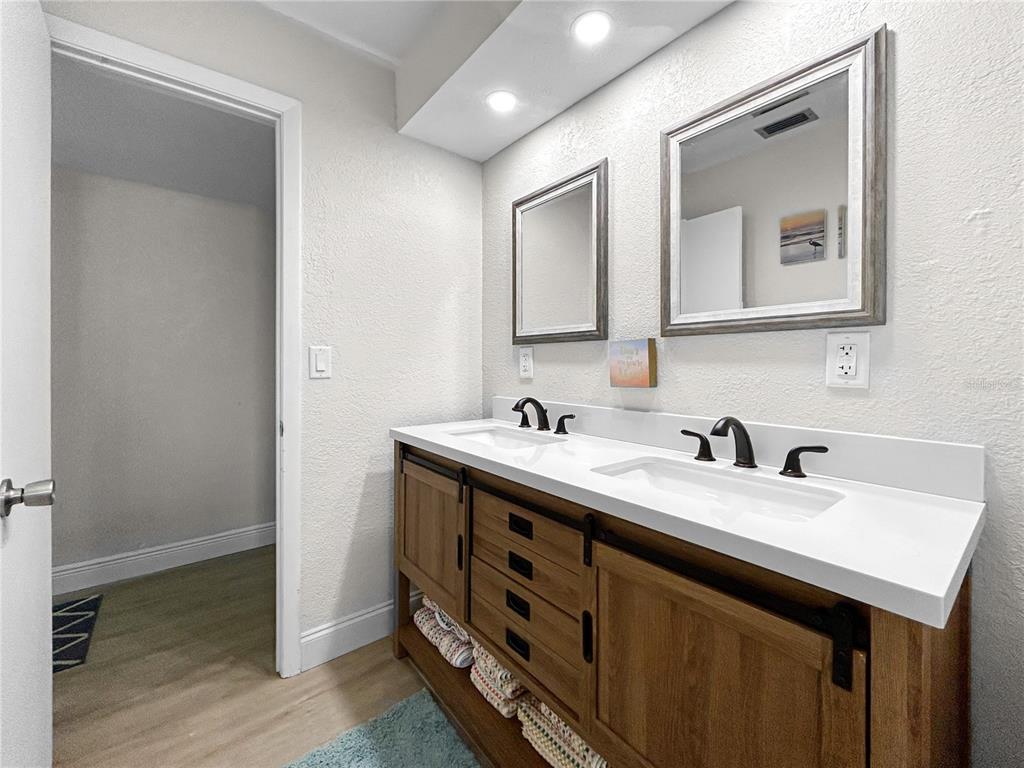 2505 Bay Boulevard, Unit 1 Indian Rocks Beach, FL 33785 - Photo 20 of 25 a bathroom with a double vanity sink and a mirror