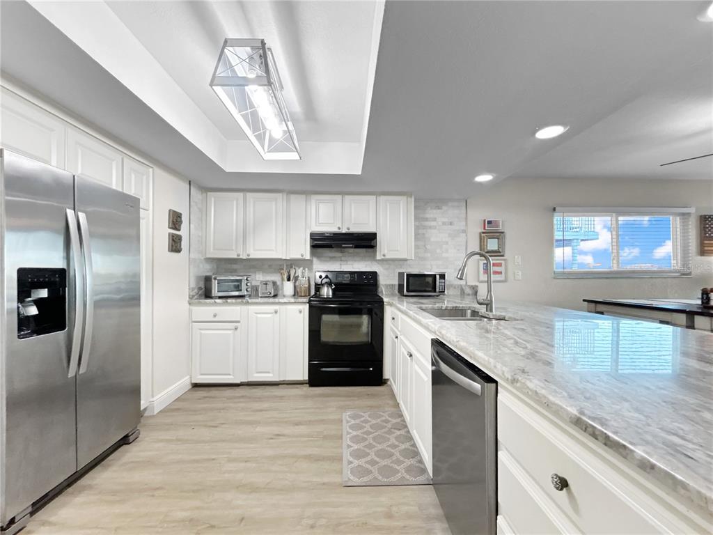 2505 Bay Boulevard, Unit 1 Indian Rocks Beach, FL 33785 - Photo 6 of 25 a kitchen with a sink stainless steel appliances and cabinets