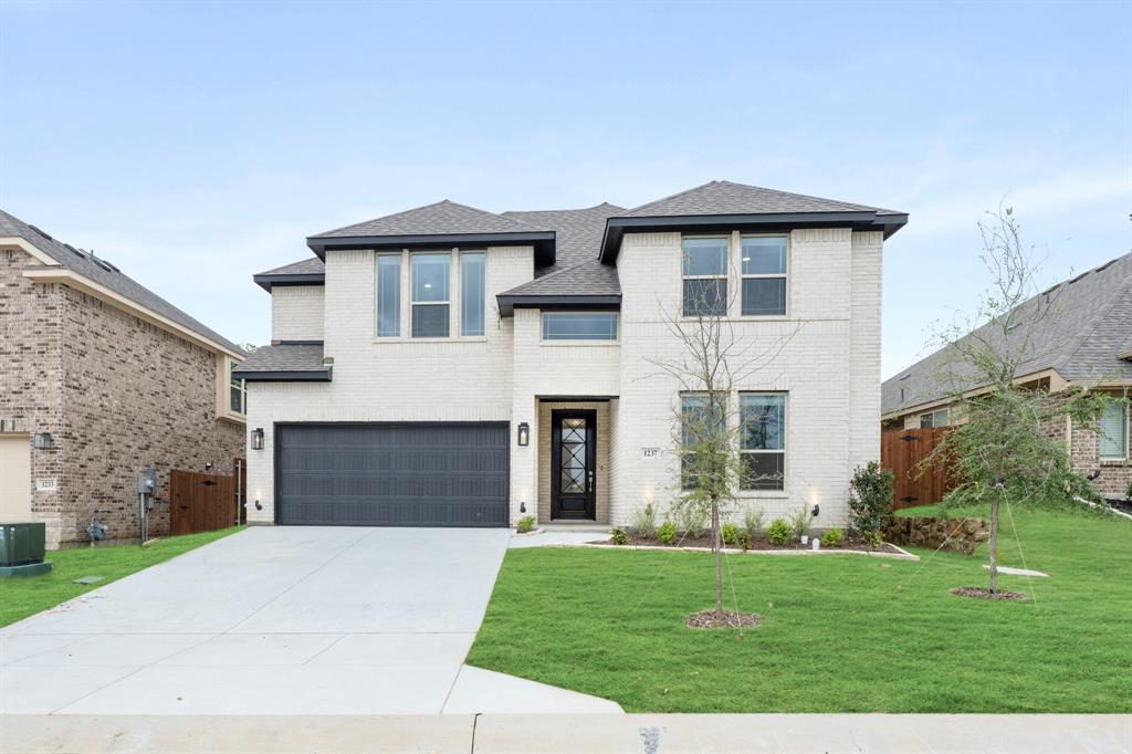 1237 Grand Mdws Drive Godley, TX 76044 - Photo 1 of 1 a front view of a house with a garden and yard