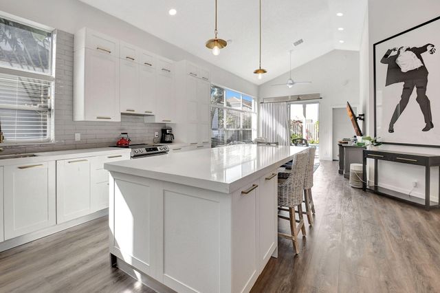 a kitchen with a table chairs sink and cabinets
