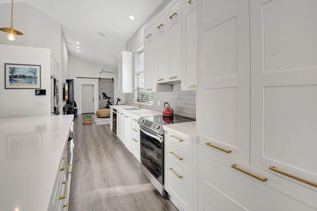 a kitchen with white cabinets and white appliances
