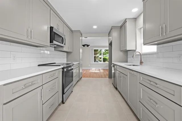 a kitchen with stainless steel appliances a sink stove and cabinets