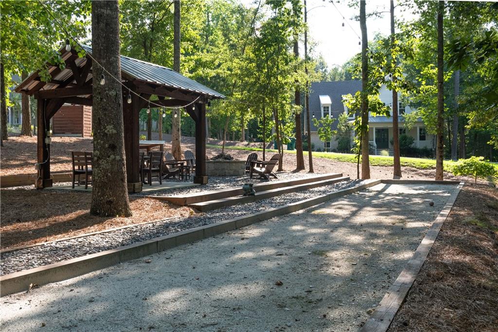 13585 Wood Fern Way Roswell, GA 30075 - Photo 4 of 12 a view of a patio with a table and chairs under an umbrella with large trees