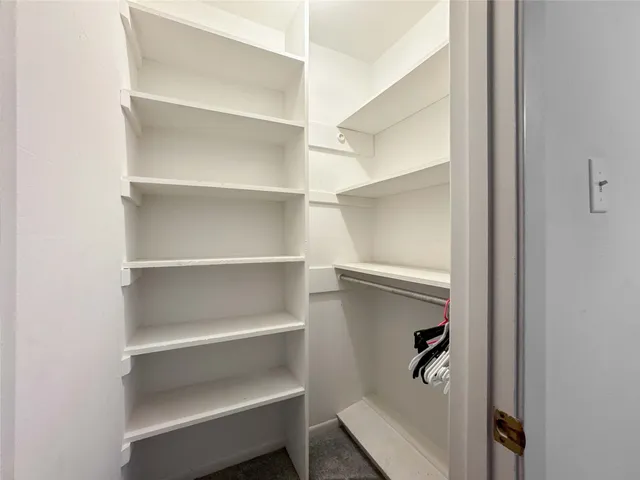a view of walk in closet with empty racks