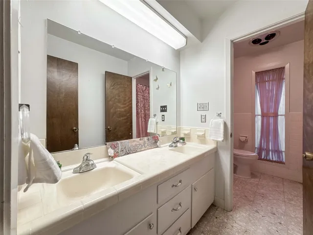 a bathroom with a double vanity sink and a mirror