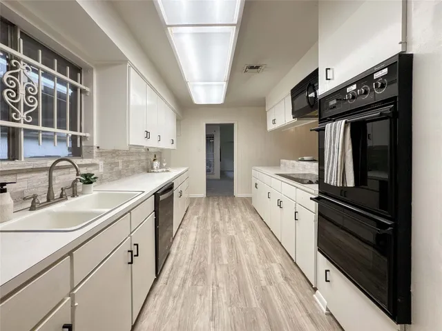 a spacious kitchen with stainless steel appliances granite countertop lots of counter space and wooden floors
