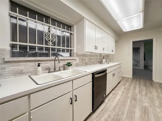 a kitchen with a sink cabinets and window