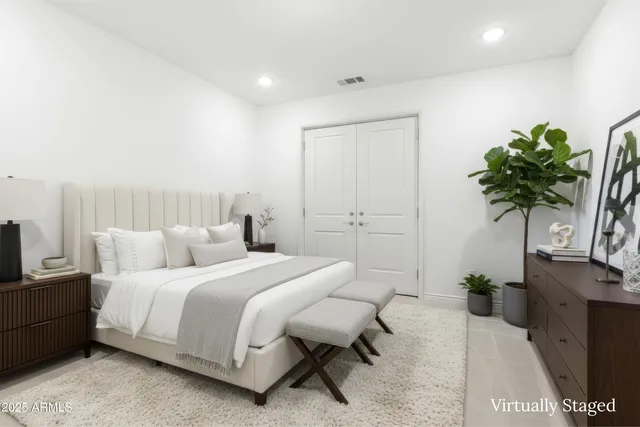 a bedroom with a bed and a potted plant