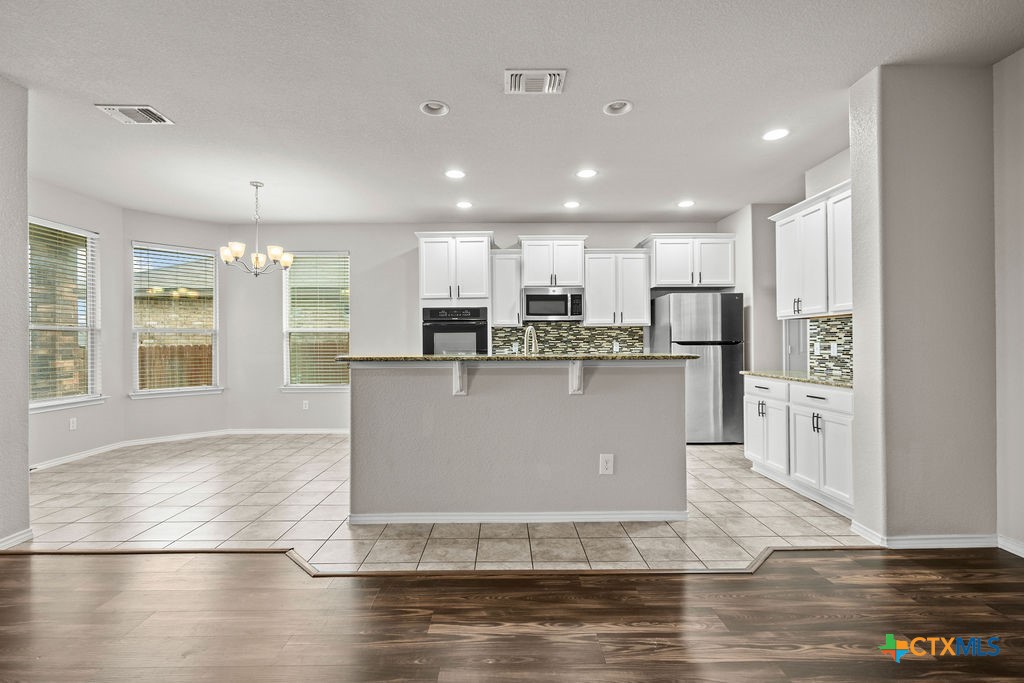 Undisclosed Address Temple, TX 76502 - Photo 7 of 36 a view of a kitchen with stainless steel appliances granite countertop a stove a sink a refrigerator and white cabinets with wooden floor
