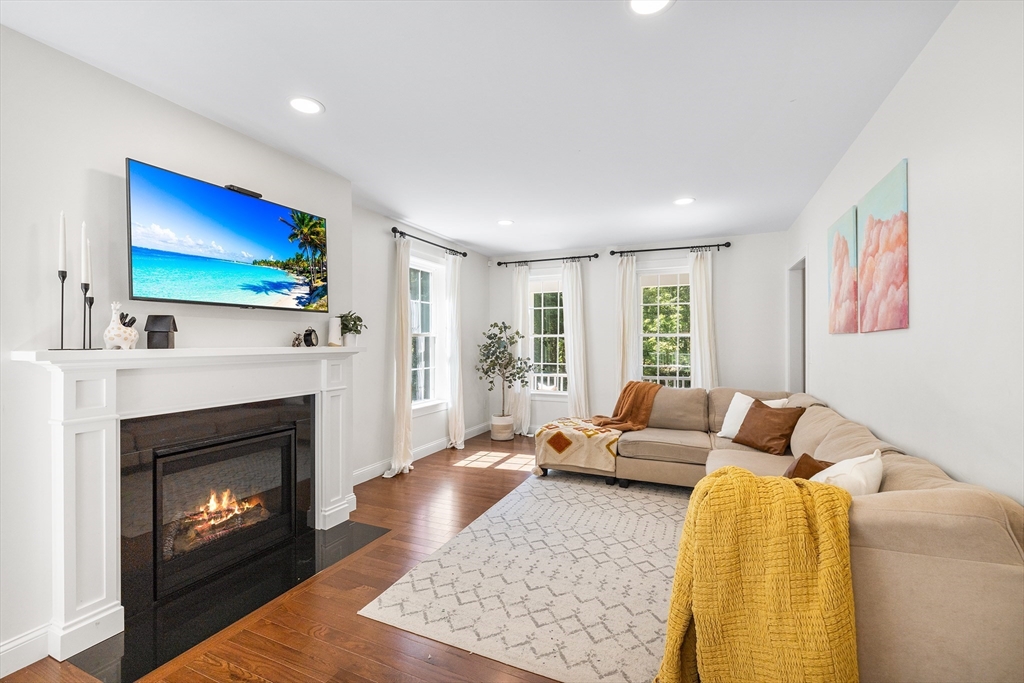 236 Pepperell Road Groton, MA 01450 - Photo 9 of 42 a living room with furniture a flat screen tv and a fireplace